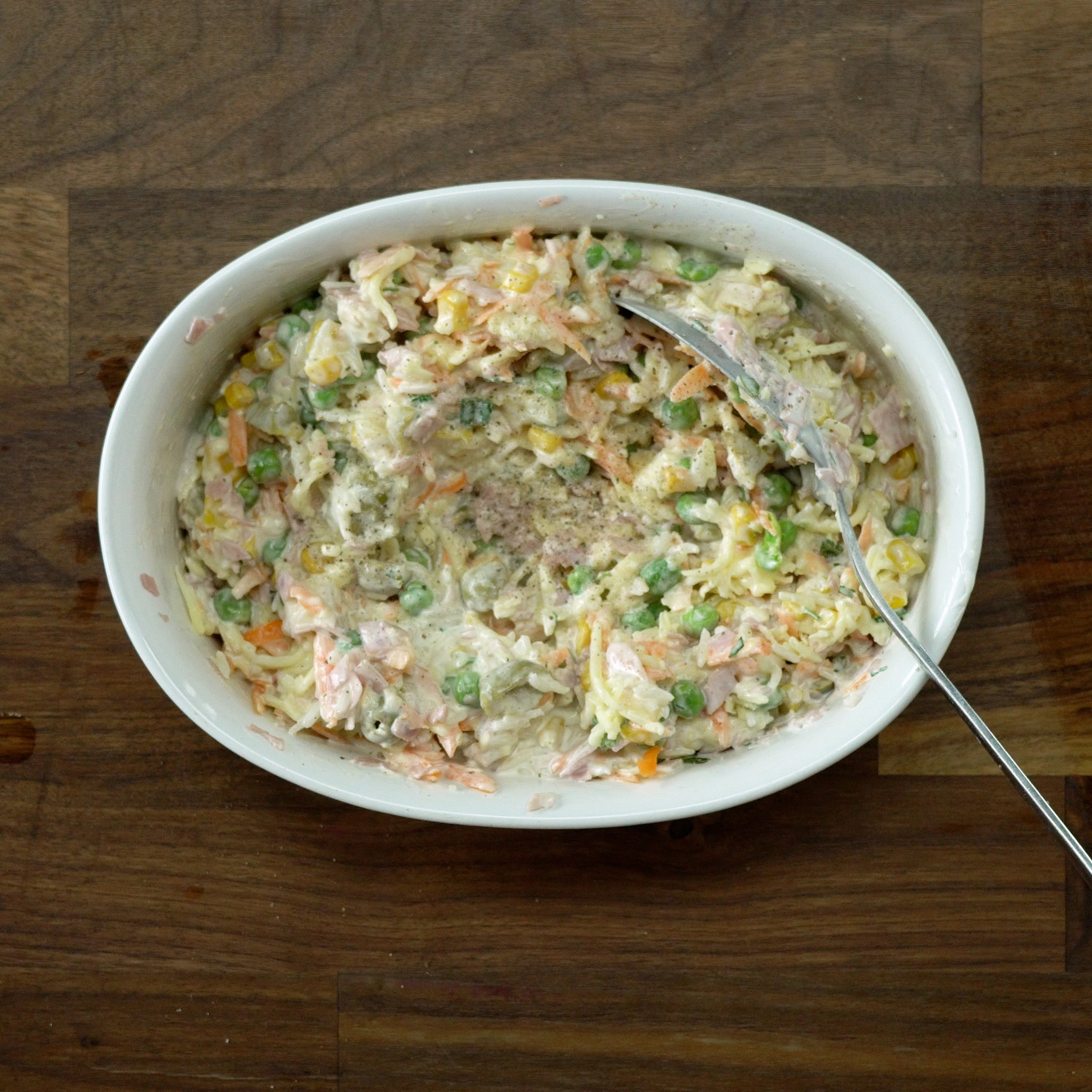 Seasoning the baked creamy rice with salt and black pepper.