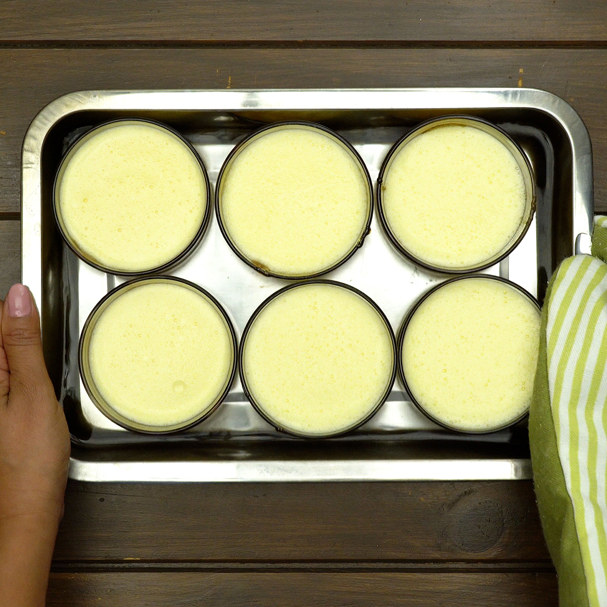 Creamy flan baking in a water bath until the center is set.