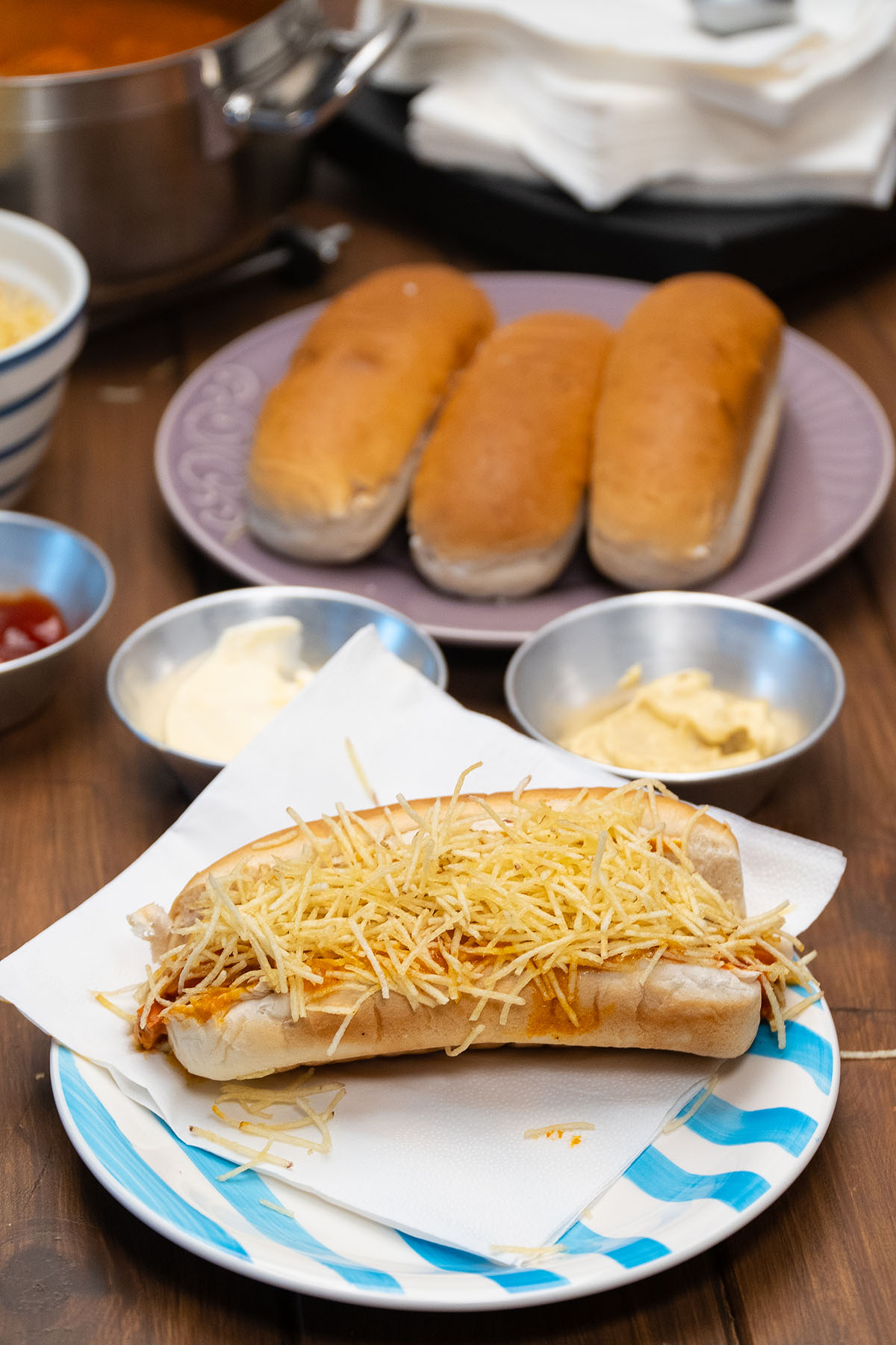 Brazilian-style hot dogs with tomato sausage sauce and potato sticks.