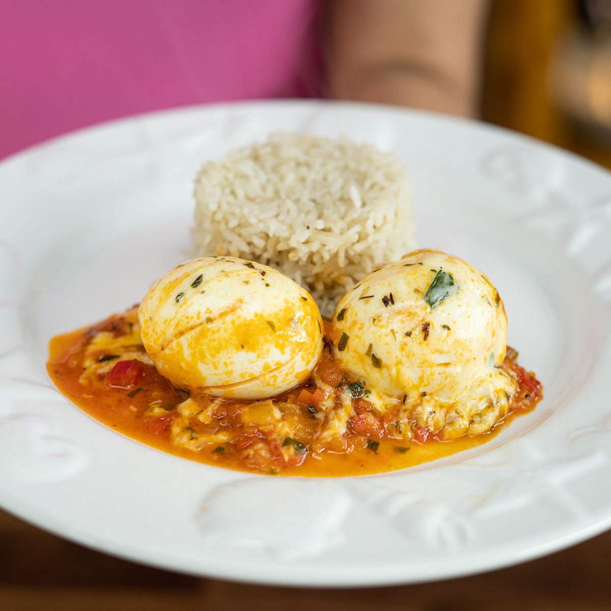 Cheesy eggs with tomato sauce served alongside rice.