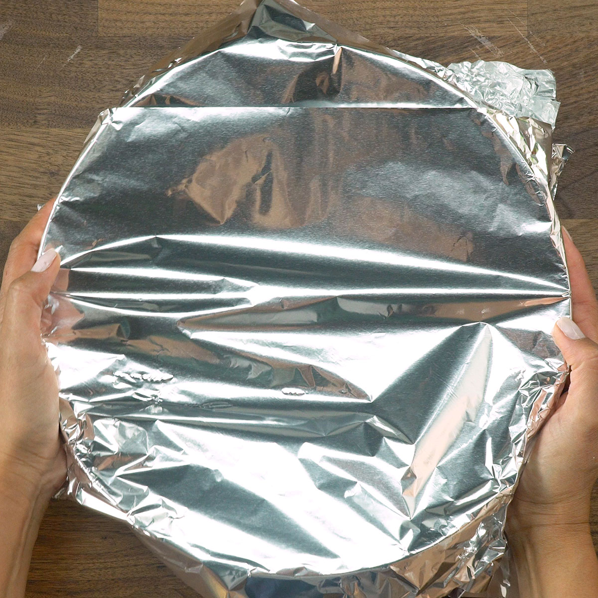 Seasoned chicken covered with aluminum foil before baking.