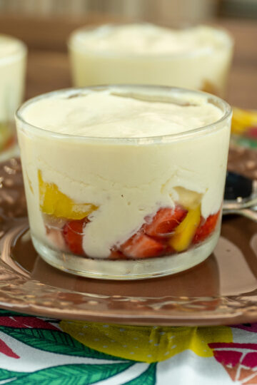 Chilled fruit salad with passion fruit mousse served in a glass.
