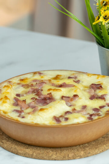 Creamy baked yuca casserole with bacon coming out of the oven ready to serve.