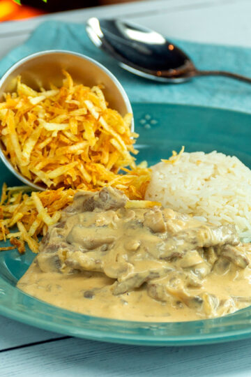 Creamy Brazilian beef stroganoff served with white rice and crispy potato sticks.