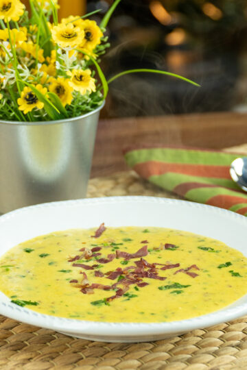 Creamy corn with bacon being served on a plate.