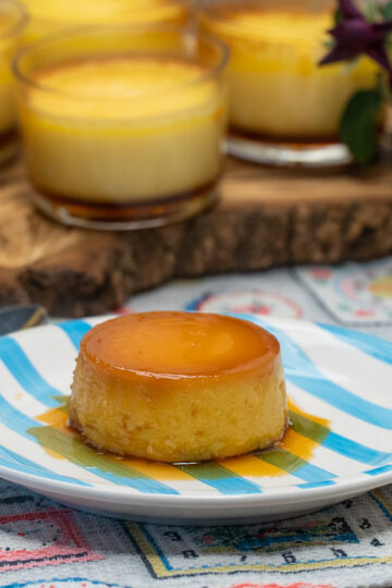 Creamy caramel flan being served on a dessert plate.