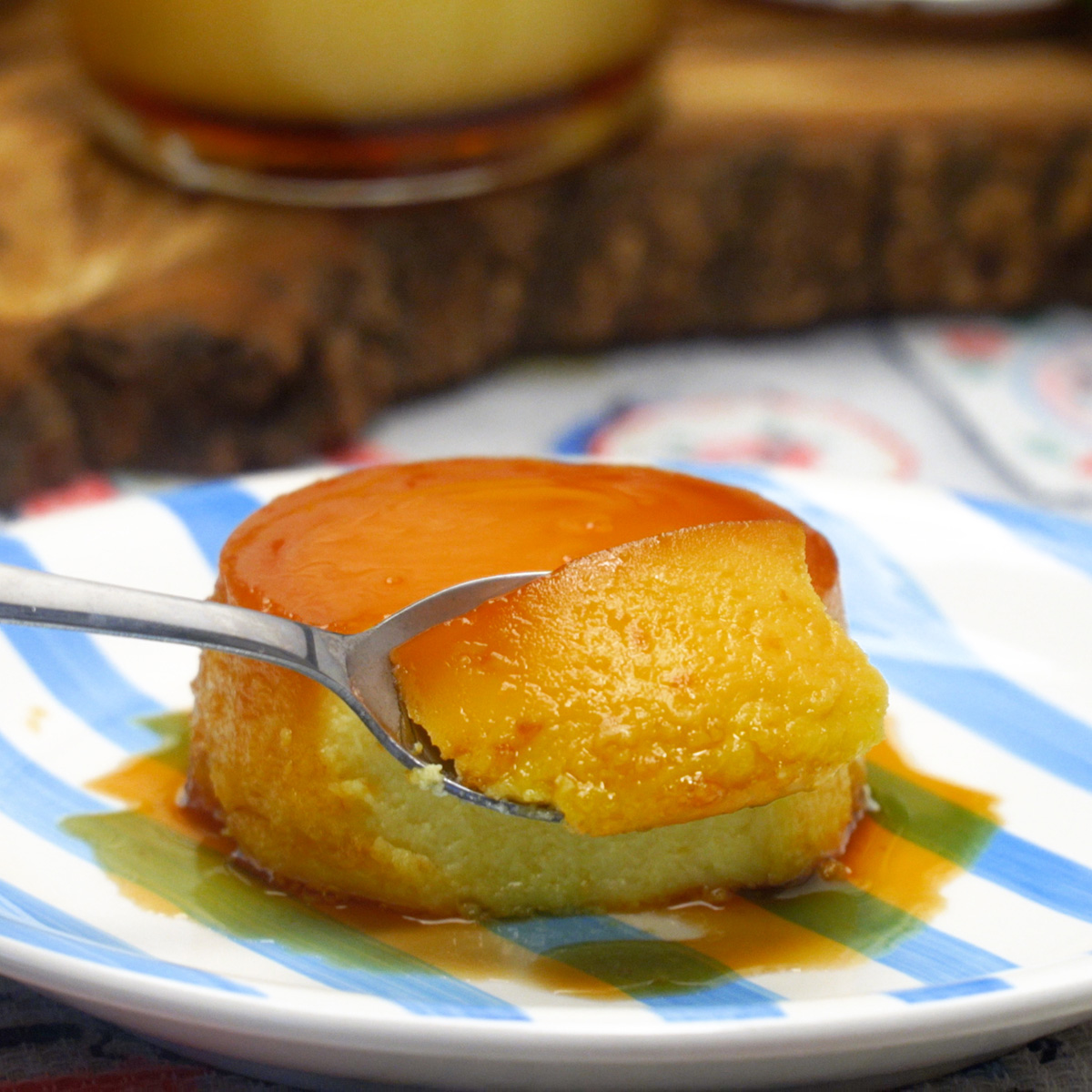 Creamy flan being tasted with a spoon.