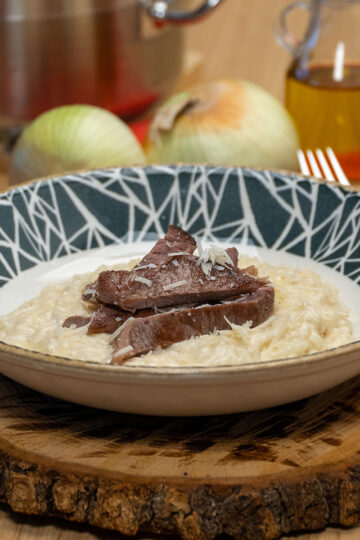 Creamy Parmesan rice served with grilled steak on top.