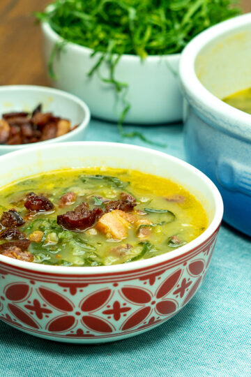 Creamy Portuguese kale soup in a bowl finished with bacon.