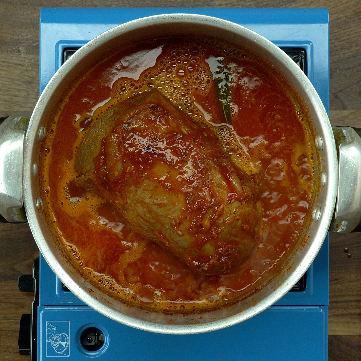Eye of round roast in the pressure cooker covered with water and seasonings.