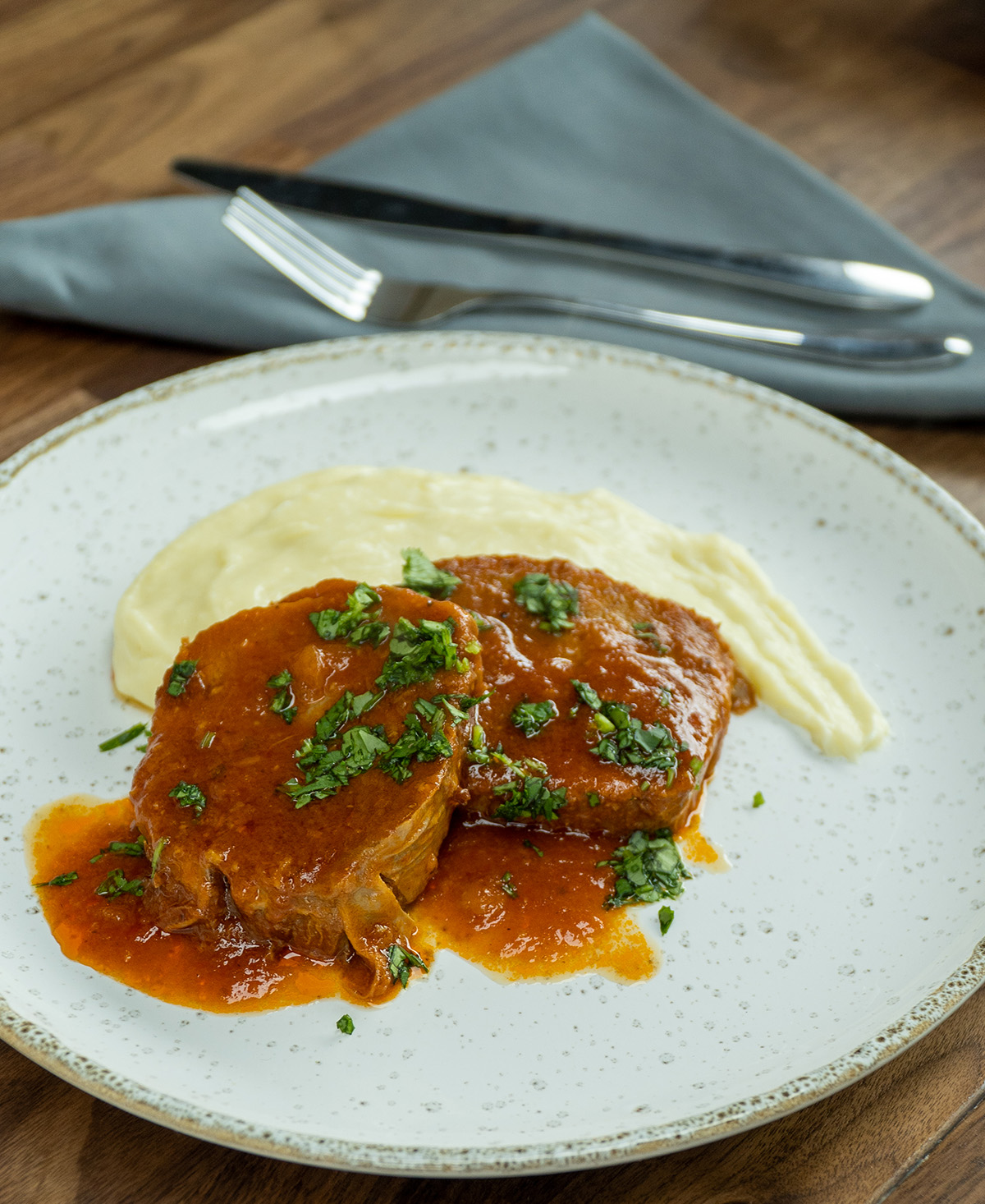 Plate with pressure cooker eye of round roast, mashed potatoes and parsley.
