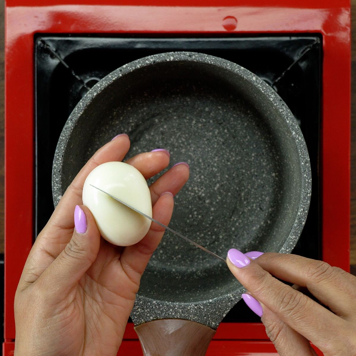 Small cuts being made on the surface of hard-boiled eggs.