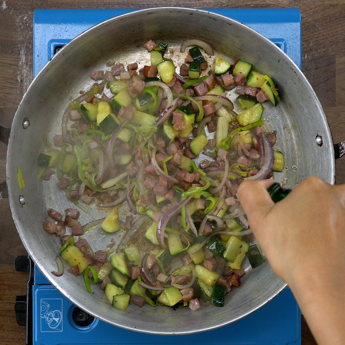 White wine being added to the sautéed ingredients.